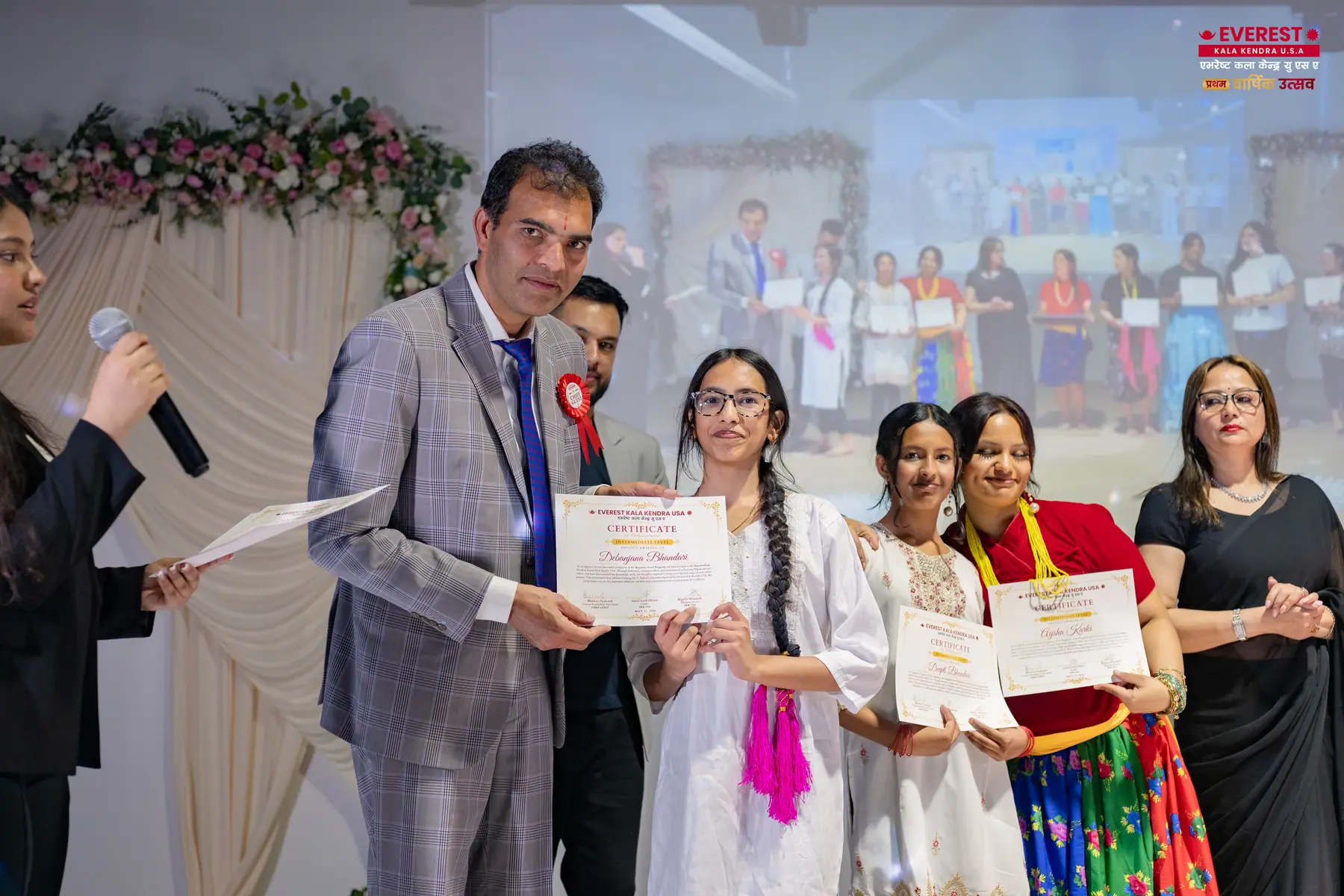 An EKK host presents achievement certificates to students at the annual function