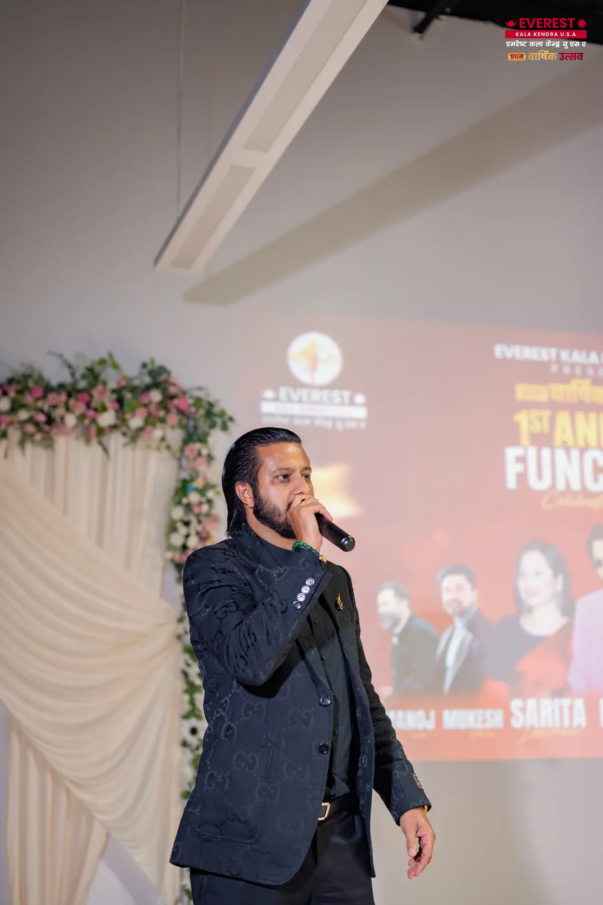 A singer performing live with a microphone at the EKK annual function