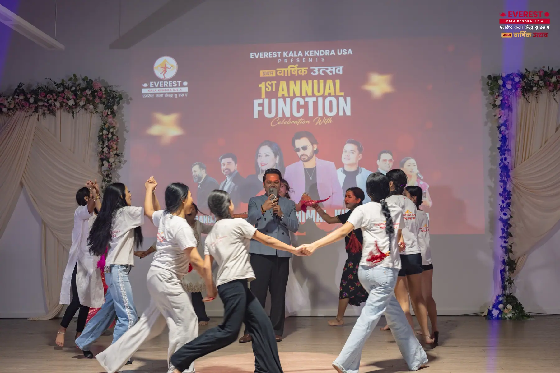 EKK students performing a paired folk dance in traditional Nepali costume