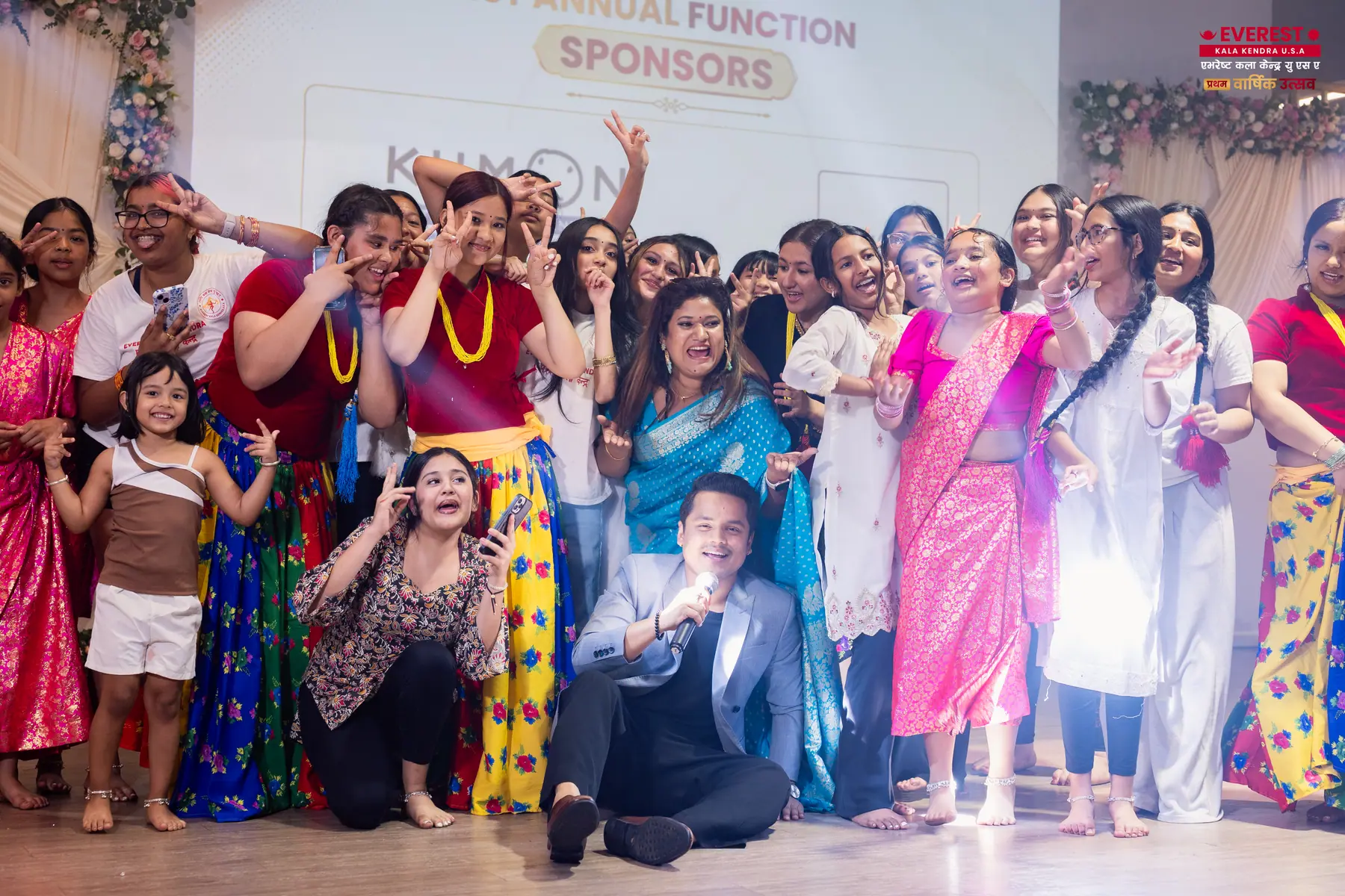 EKK performers and organizers gathered on stage with arms raised in celebration