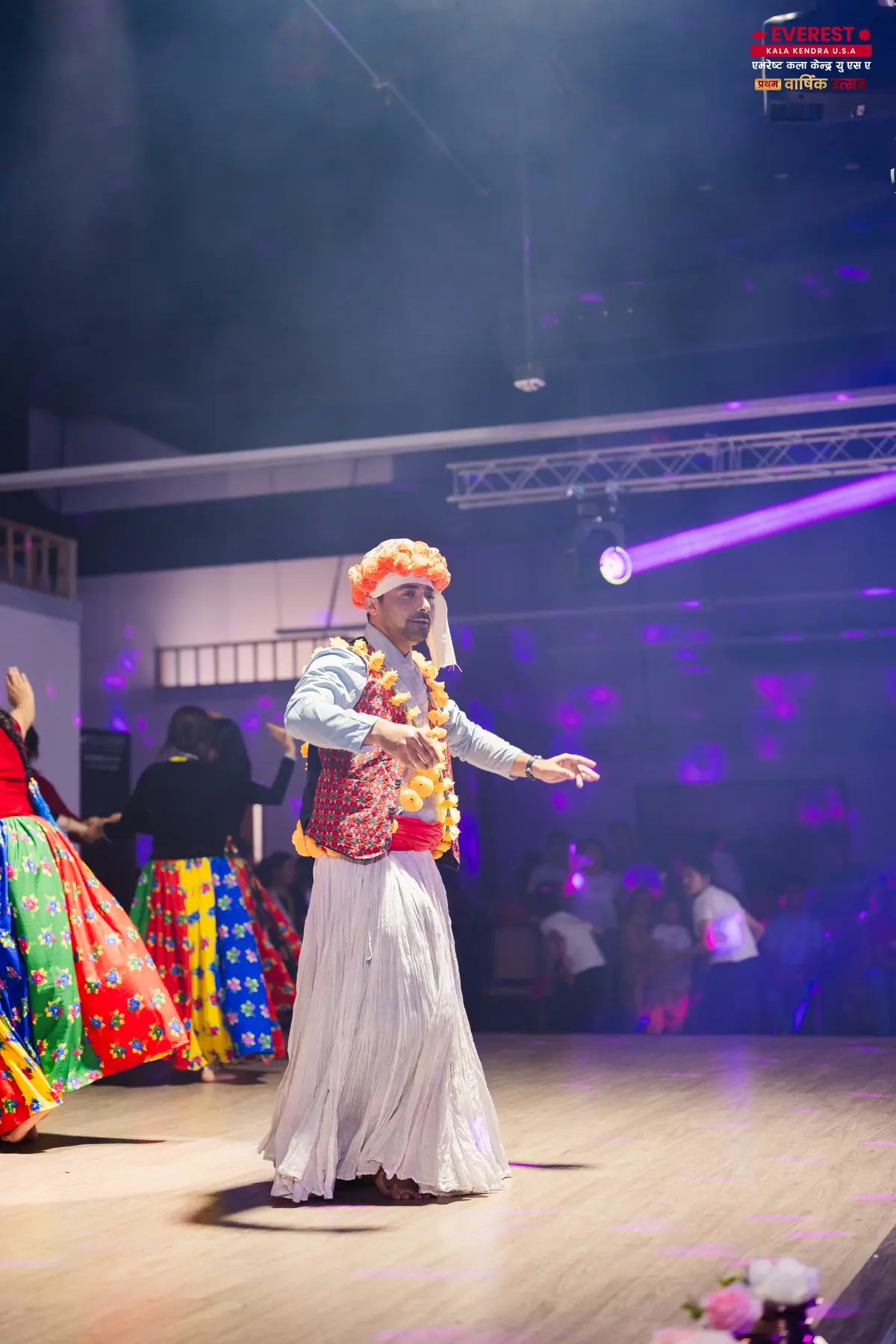 An EKK dancer in traditional costume caught in a single beam of stage light