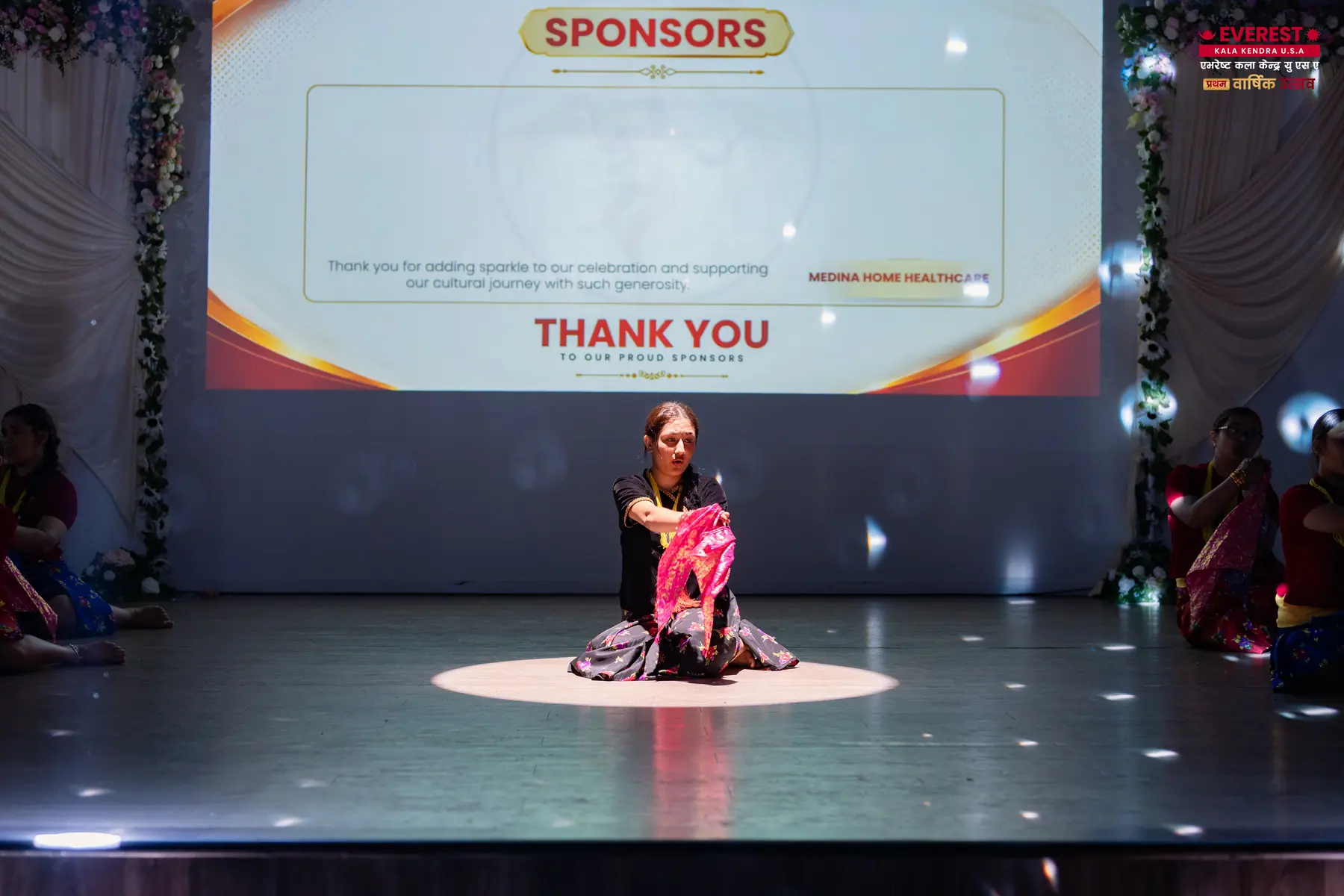 An EKK host on stage in front of a screen thanking the annual function sponsors